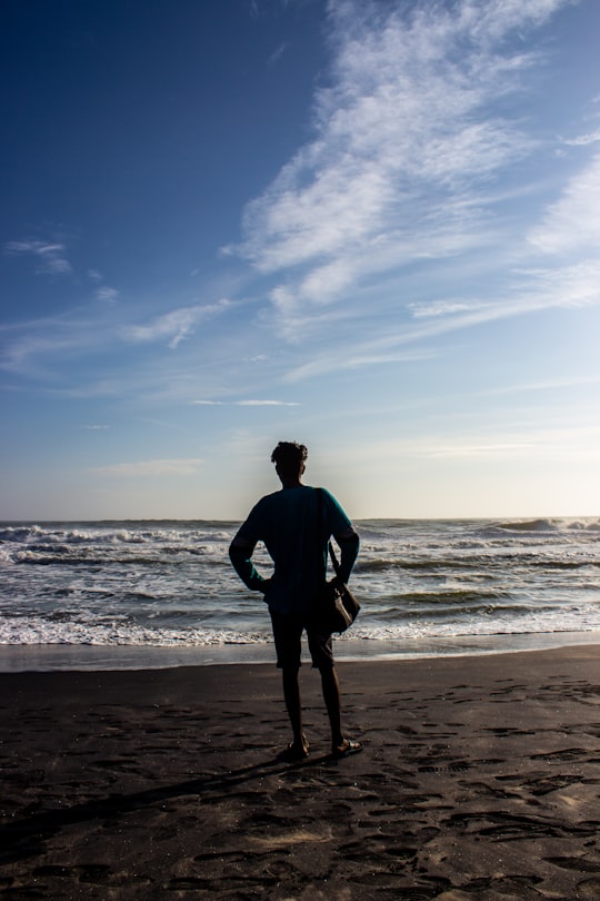 silhouette of person standing on seashore during daytime in Kovalam India