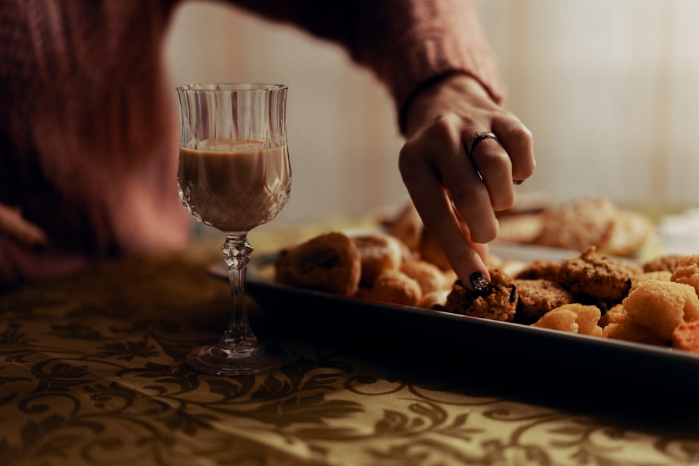 clear glass flute with liquid near pastries on tray