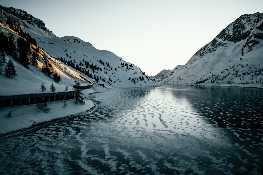 calm body of water and mountain covered with snow