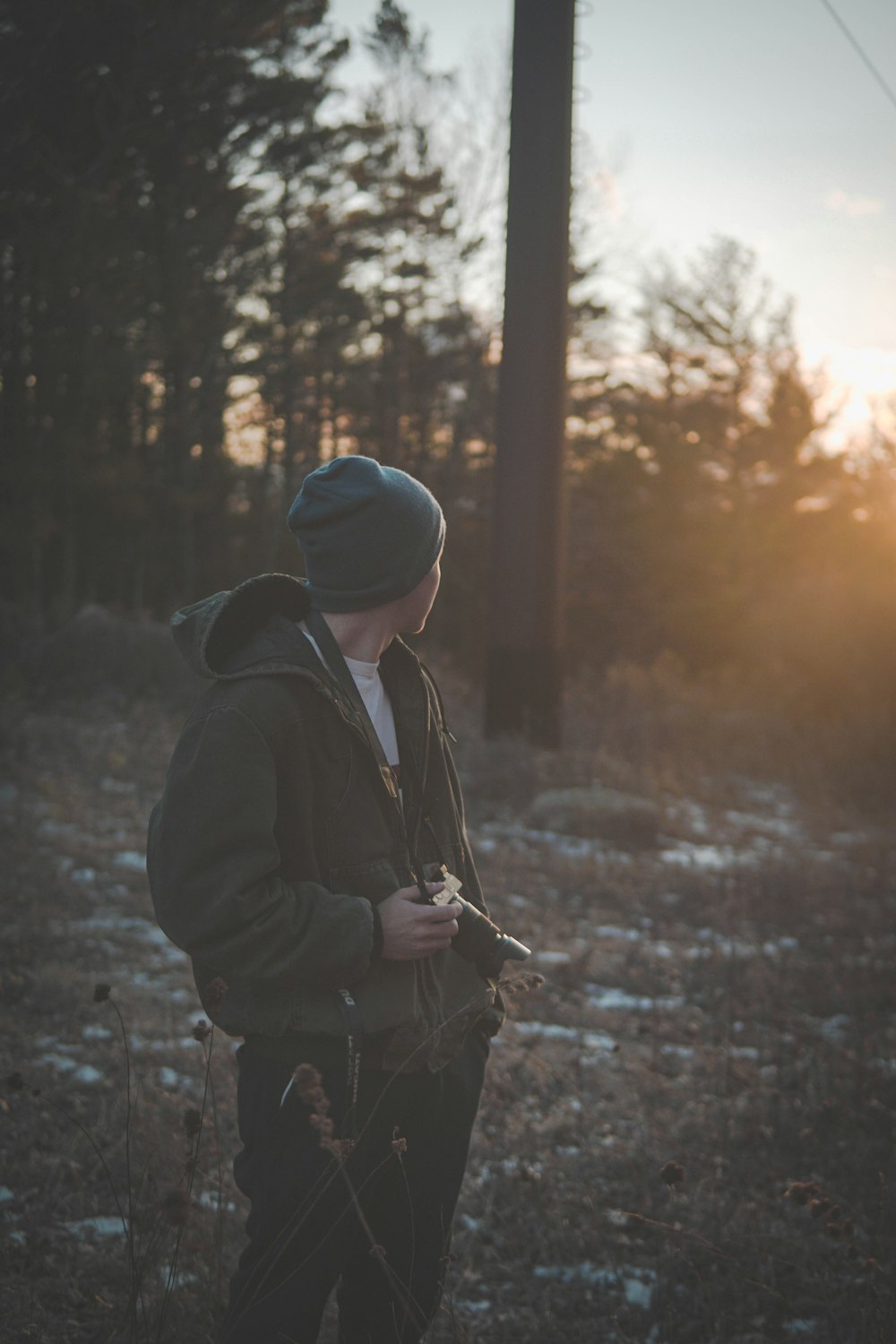 man wearing blue knit cap holding camera