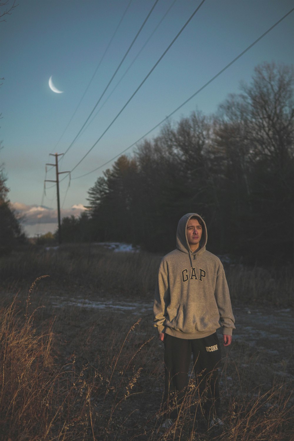 man wearing grey Gap pullover hoodie standing on the grass field