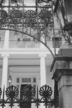 Modern aluminum gate with clean lines framing a beautiful French garden entrance.