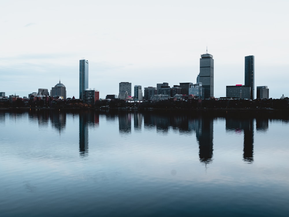 city with high-rise buildings near body of water under white sky