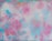 A bright, abstract painting featuring soft blues and pinks hanging on a white wall.