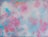 An abstract painting featuring swirling patterns of pastel colors such as pink, blue, and white. The brush strokes create a sense of movement and depth, with a soft and dreamy composition.