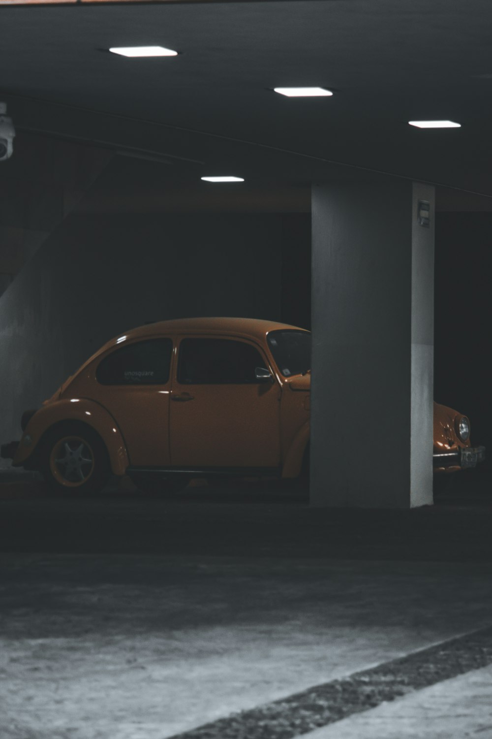 yellow Volkswagen Beetle parking on parking area