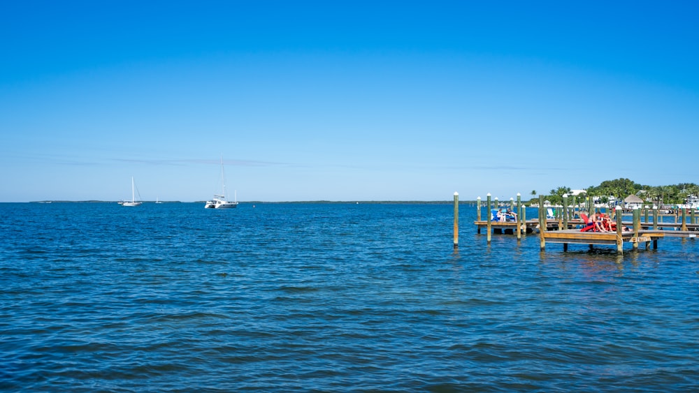 a group of people sitting on a dock in the water