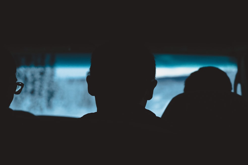 silhouette of three people inside vehicle