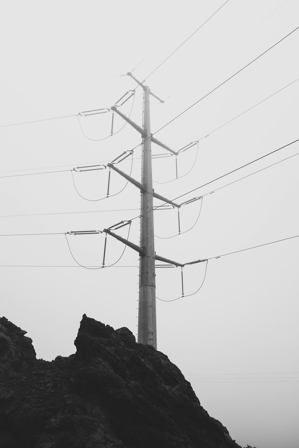 poste de transmissão cinza na colina
