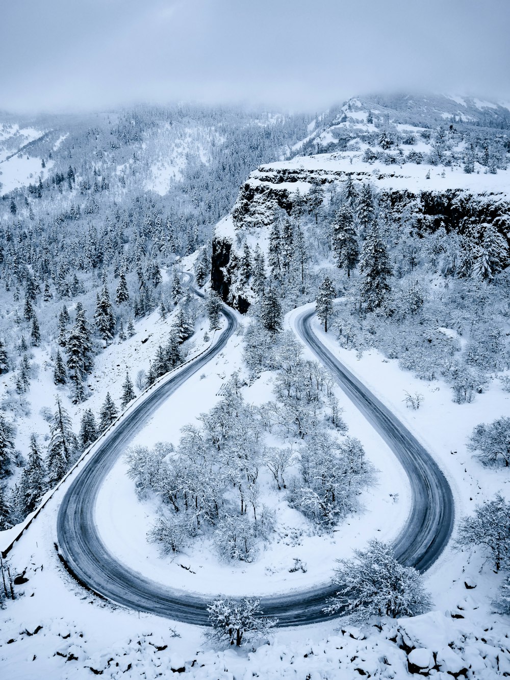 aerial photography of empty road and snow-covered field during daytime