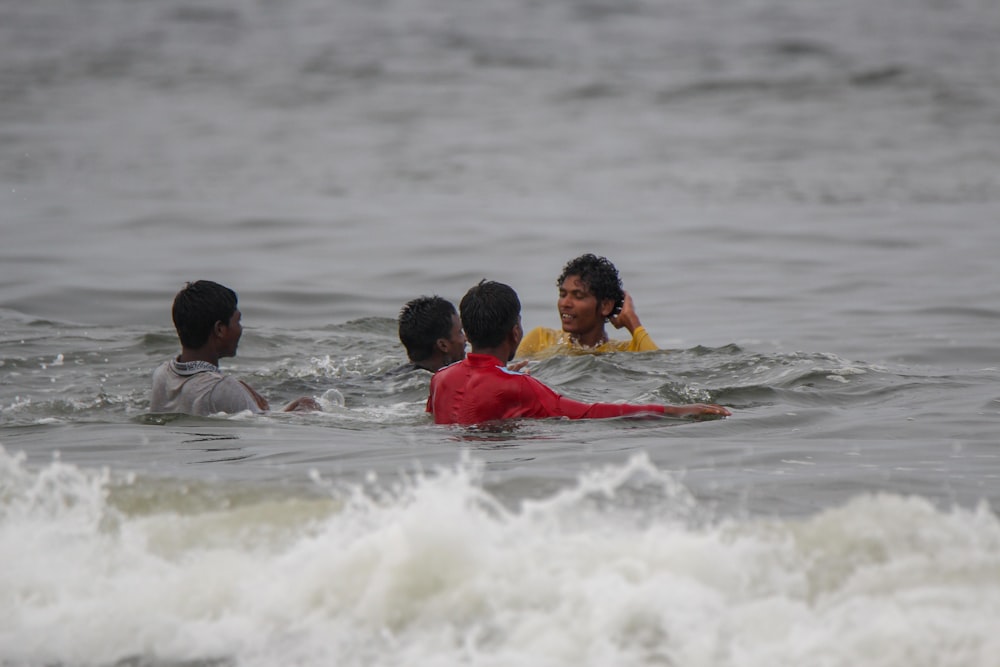 four person swimming on the pool photograph