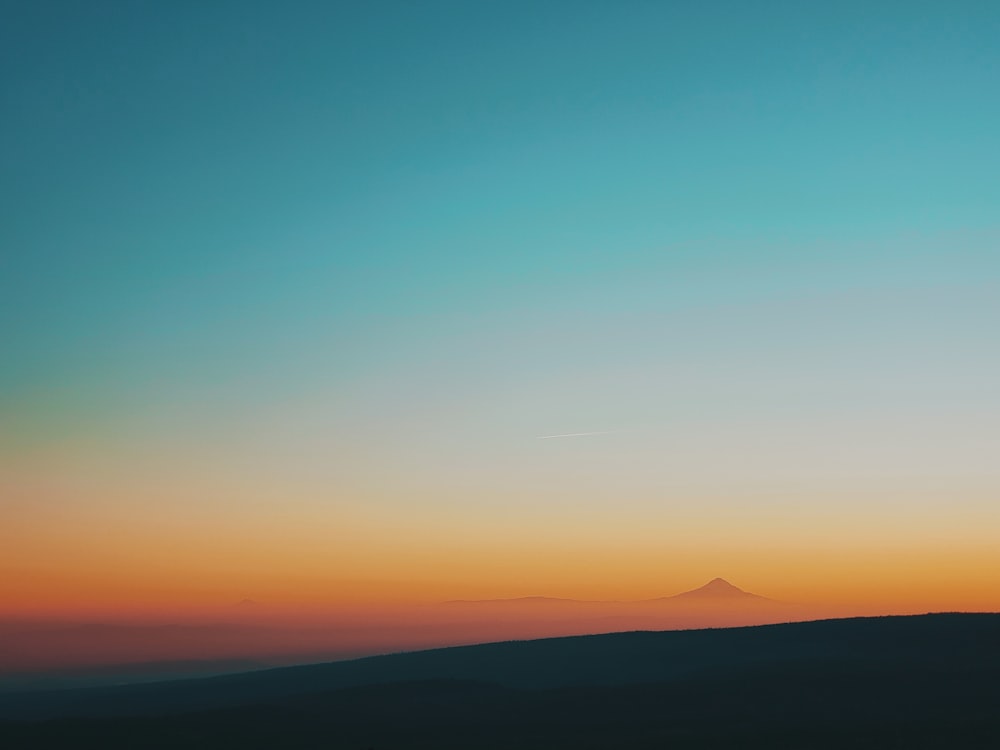 a view of a mountain at sunset from a distance