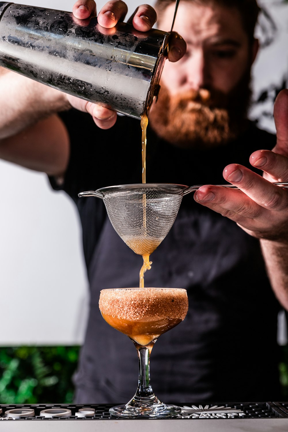 person holding strainer while pouring juice