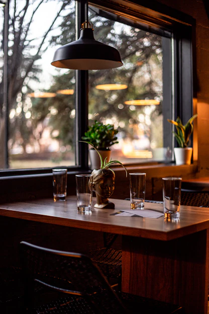 Restaurant dining area with tables, glassware, and pendant lighting
