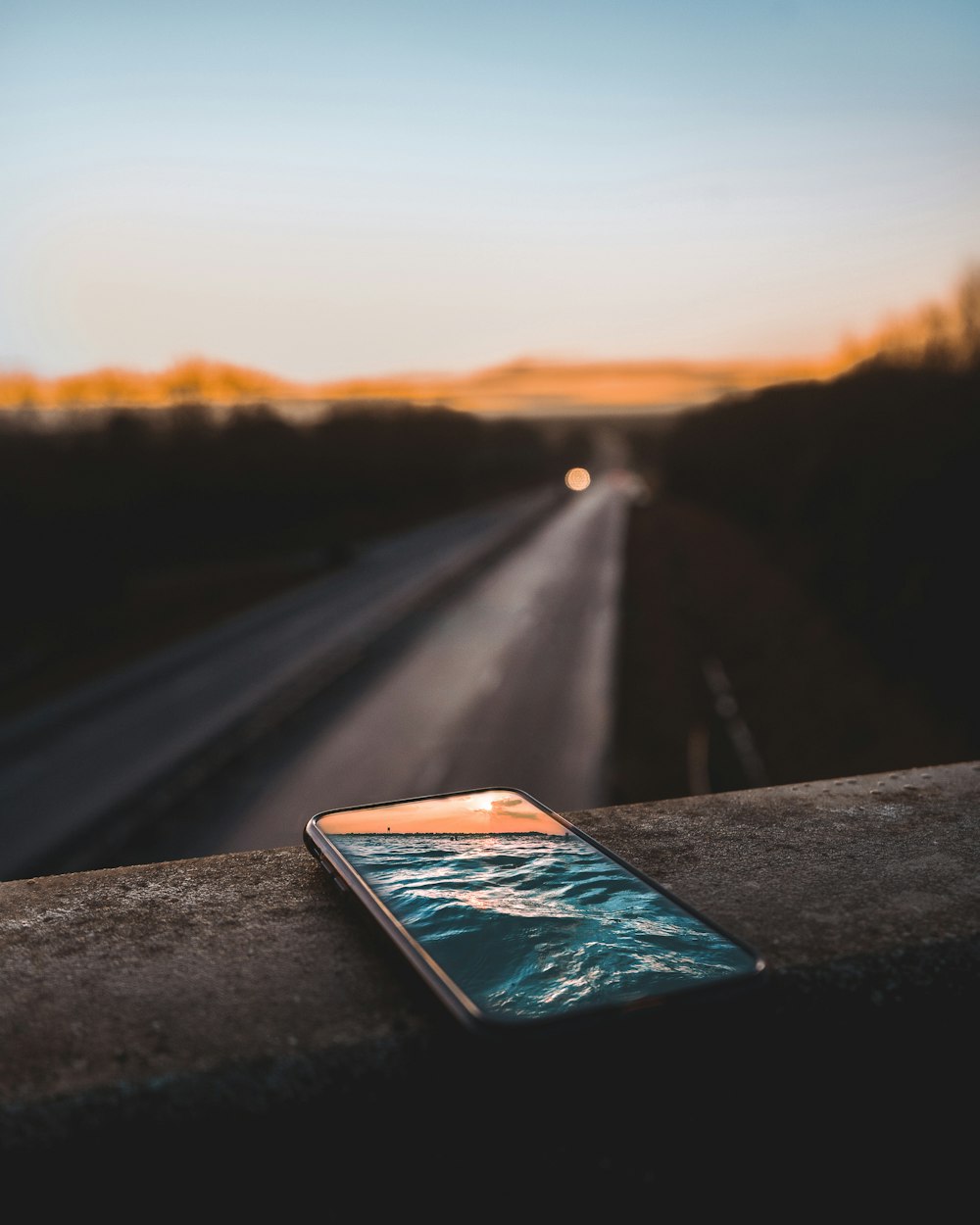 space gray iPhone Xs on concrete pavement