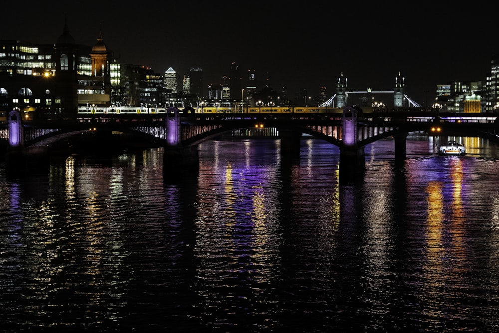 a bridge over a river with a city in the background