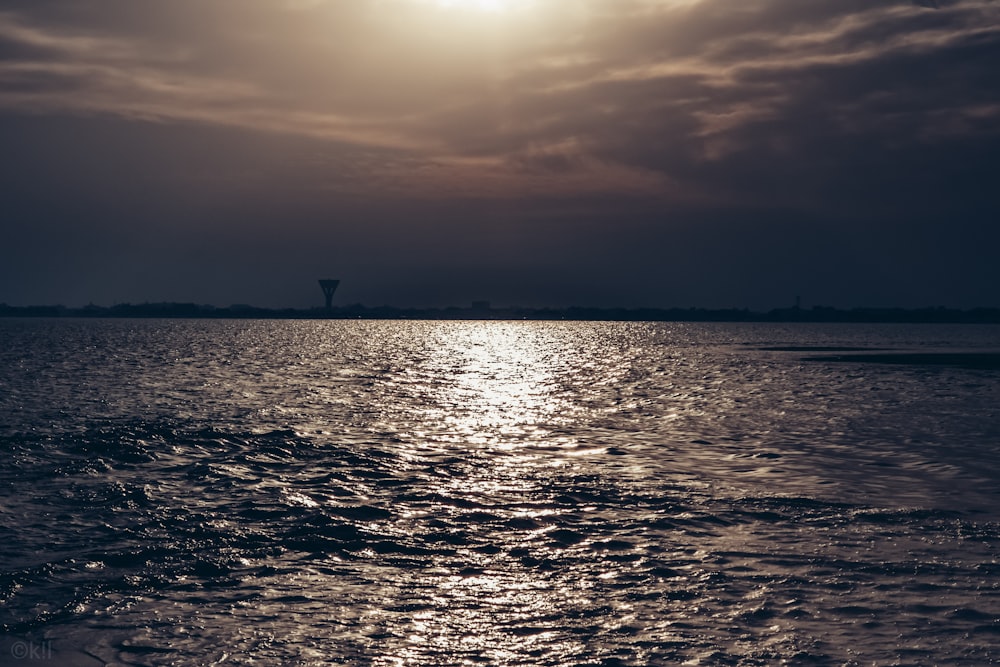 a large body of water under a cloudy sky