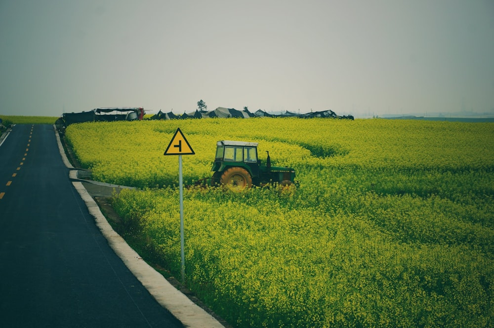 green tractor on green grass field near road