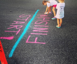 girl writing on the ground using a spray an