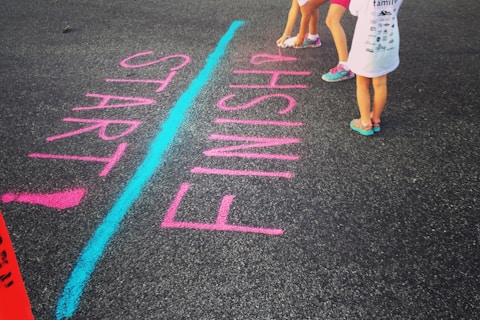 girl writing on the ground using a spray an