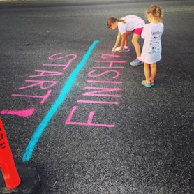 girl writing on the ground using a spray an