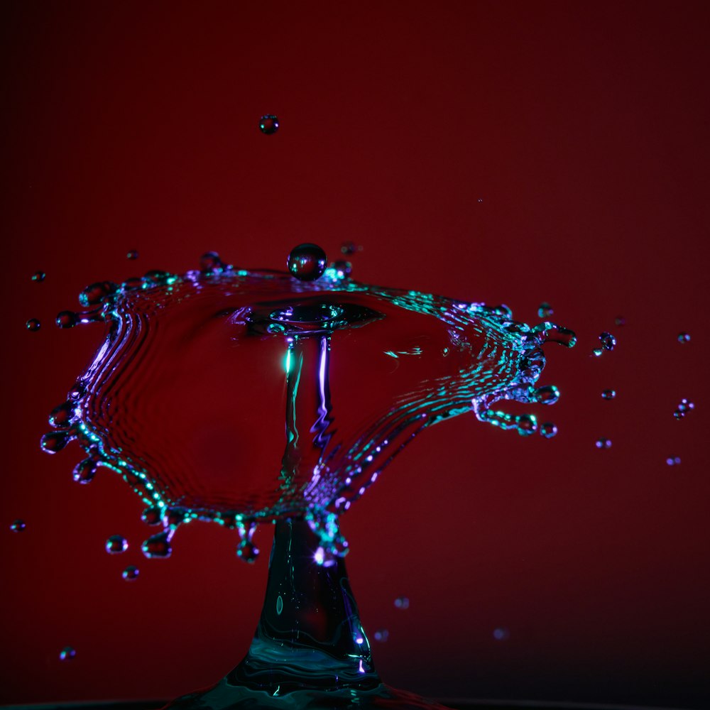 a red background with water splashing from a faucet