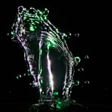 A dynamic video still showing fluid shapes in black and silver with neon cyan accents.