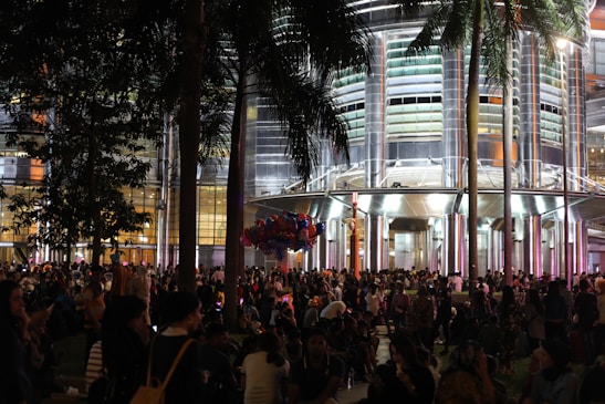 A vibrant crowd enjoying an outdoor event at a modern architectural venue.