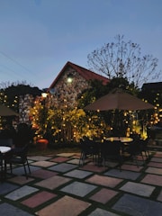 Cozy outdoor terrace with vibrant cushions and string lights at dusk.