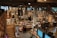 An expansive bookstore with multiple levels and wooden bookshelves filled with a variety of books. People are browsing and walking around the store. The space is well-lit with overhead lights, and there are some plants placed strategically to enhance the atmosphere.