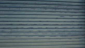 Close-up of a professional inspecting garage door cables and rollers.