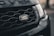 Close-up of a Land Rover grille, showcasing the distinct logo with a dark, textured background adding depth.