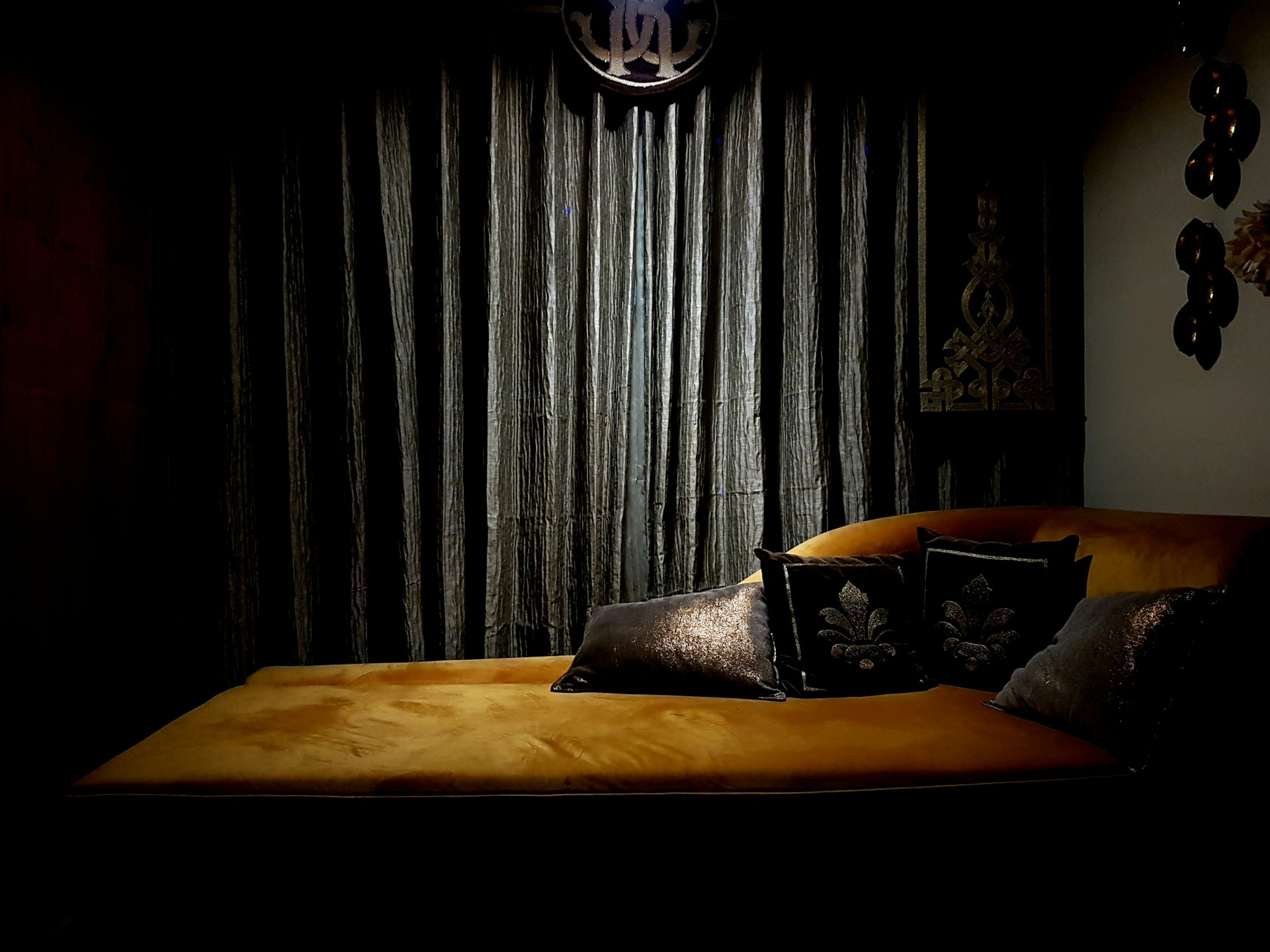 A vintage chaise lounge with plush cushions, set against a backdrop of deep red walls, inviting quiet moments of intimate reflection.