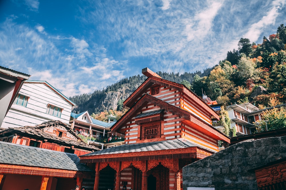 houses surrounded with green trees under blue and white sky