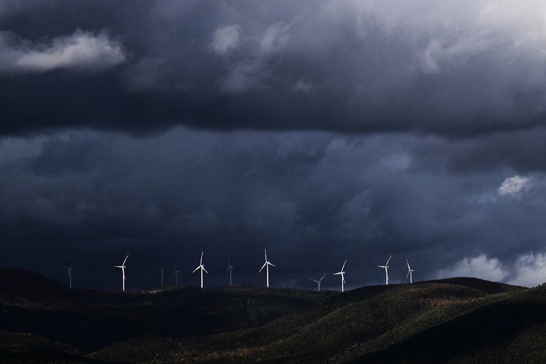 wind turbines on hill under heavy clouds