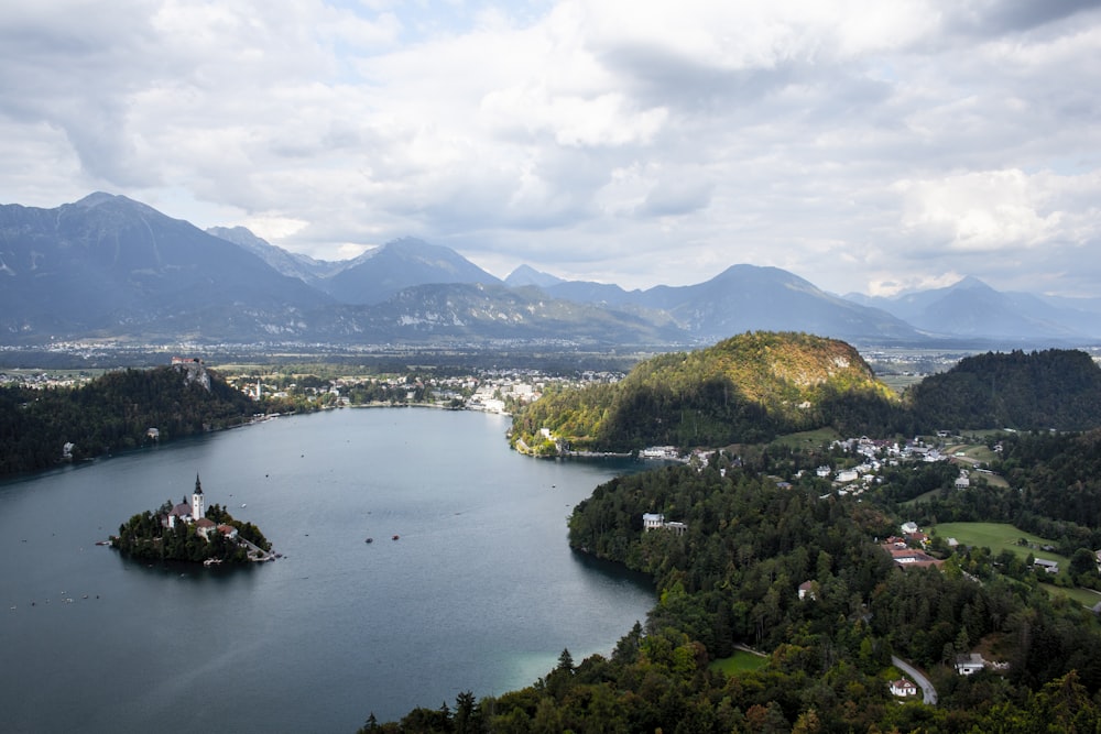 white and black tower on islet surrounded by mountains