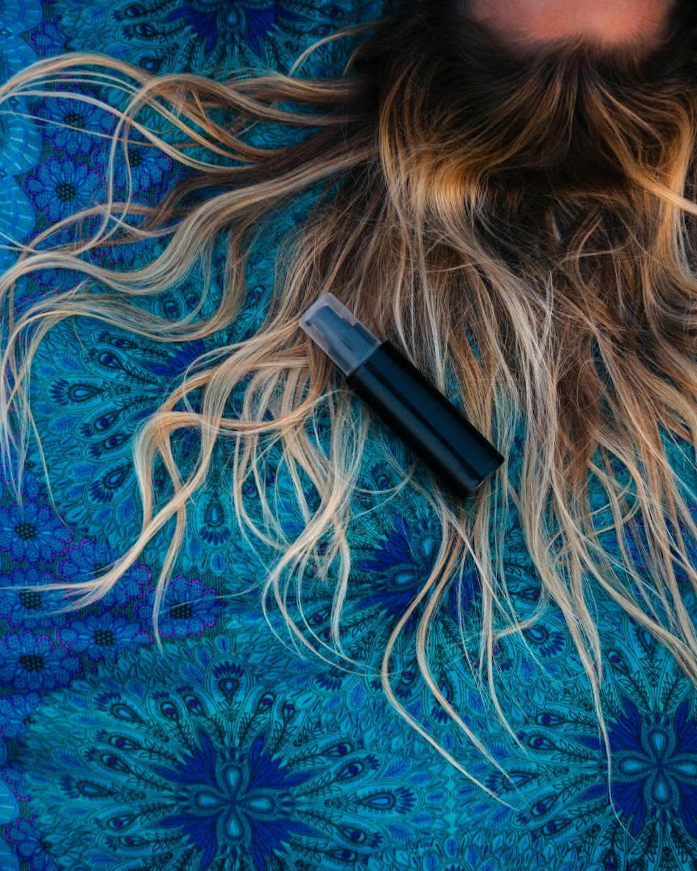 femme allongée sur textile floral bleu