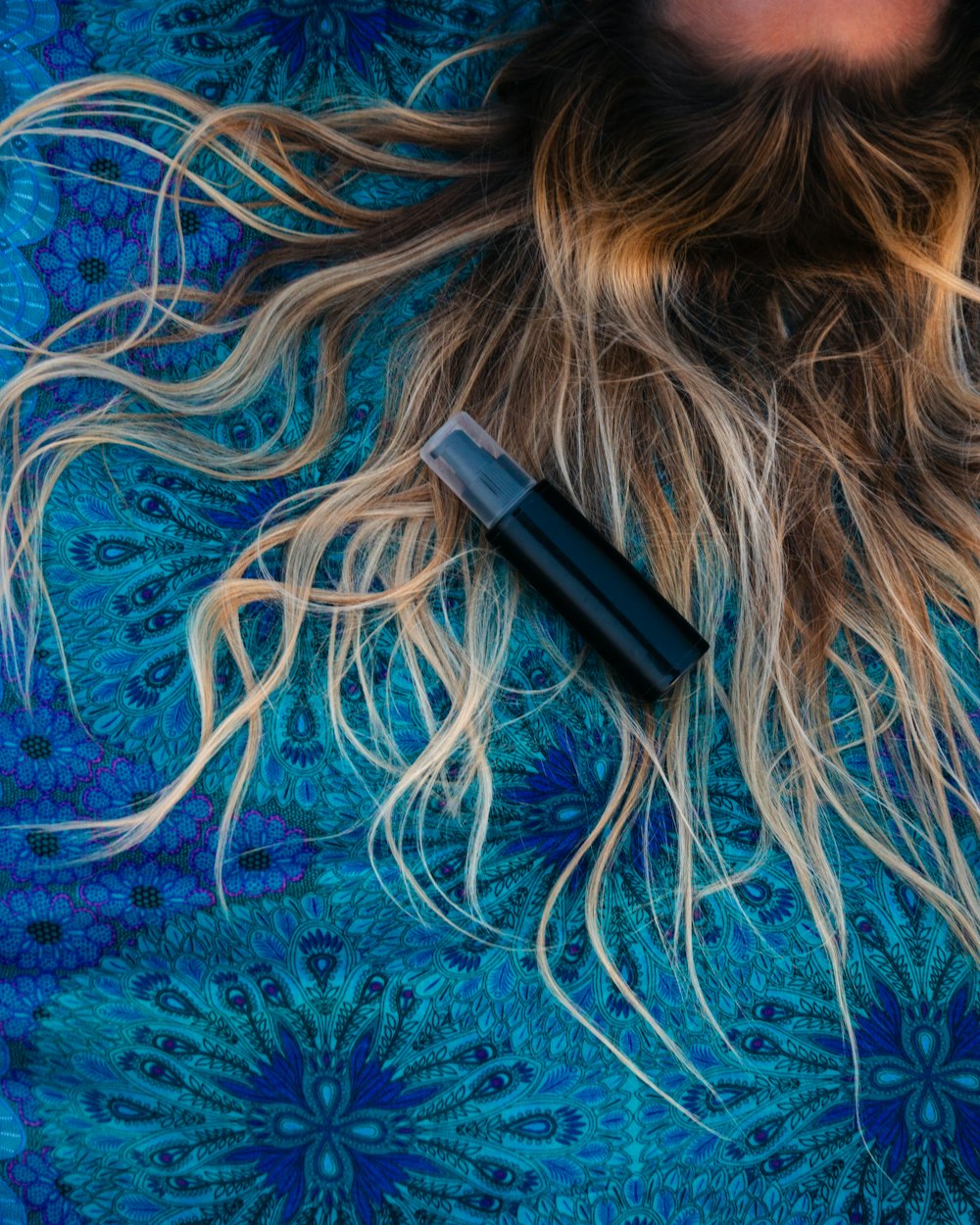 woman lying on blue floral textile