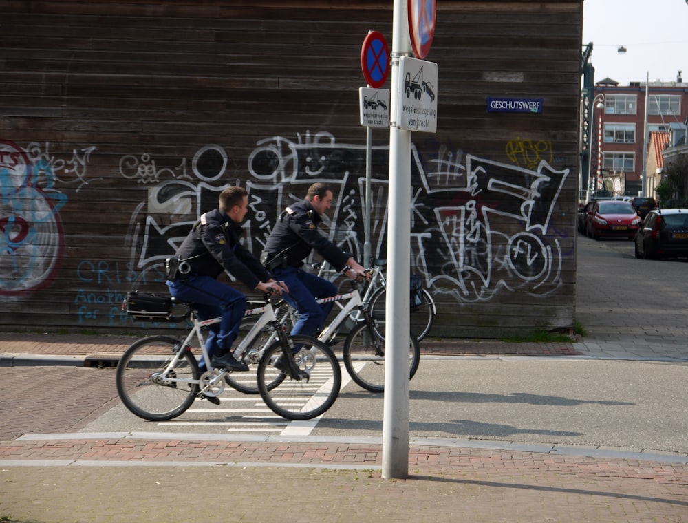 two men riding bikes on road at the city during day