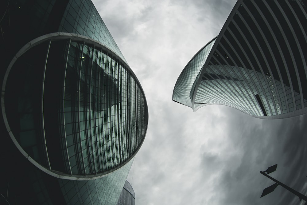 architectural photography of green high-rise buildings under white and gray sky