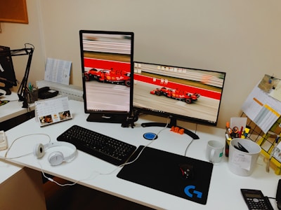 Desk with organized vehicle registration forms and a computer screen showing licensing details.