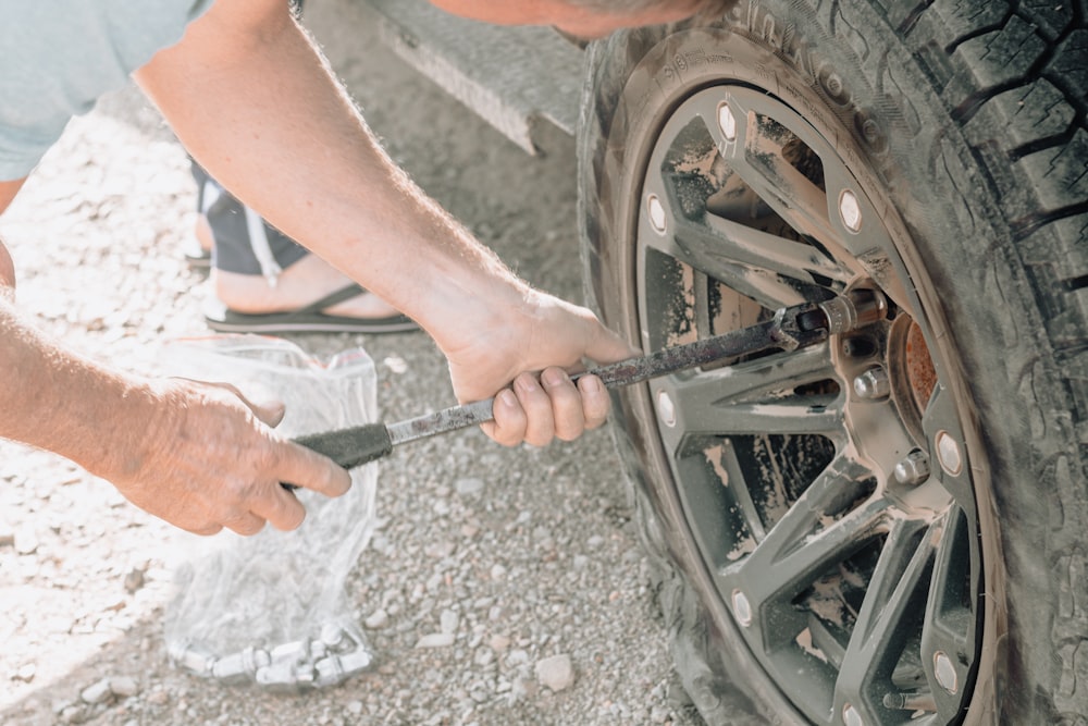 a man working on a tire with a wrench