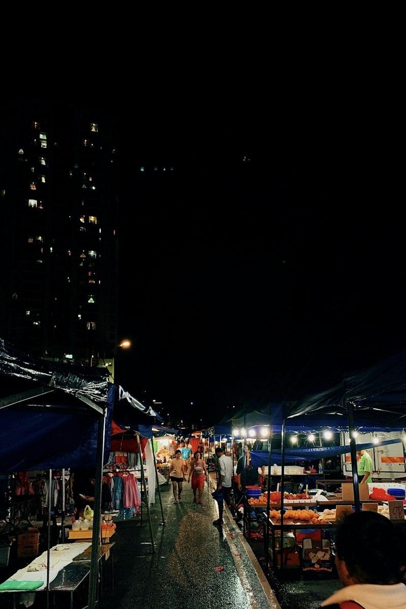 People and canopy stores at a night market in Thailand