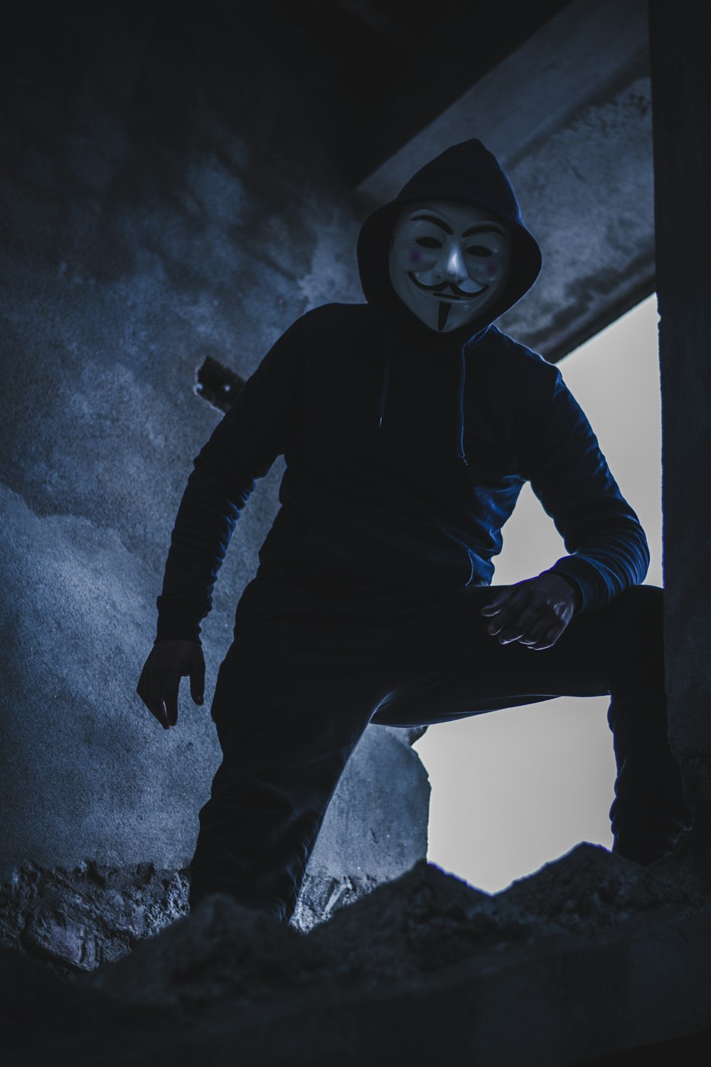 man in black hoodie standing beside window