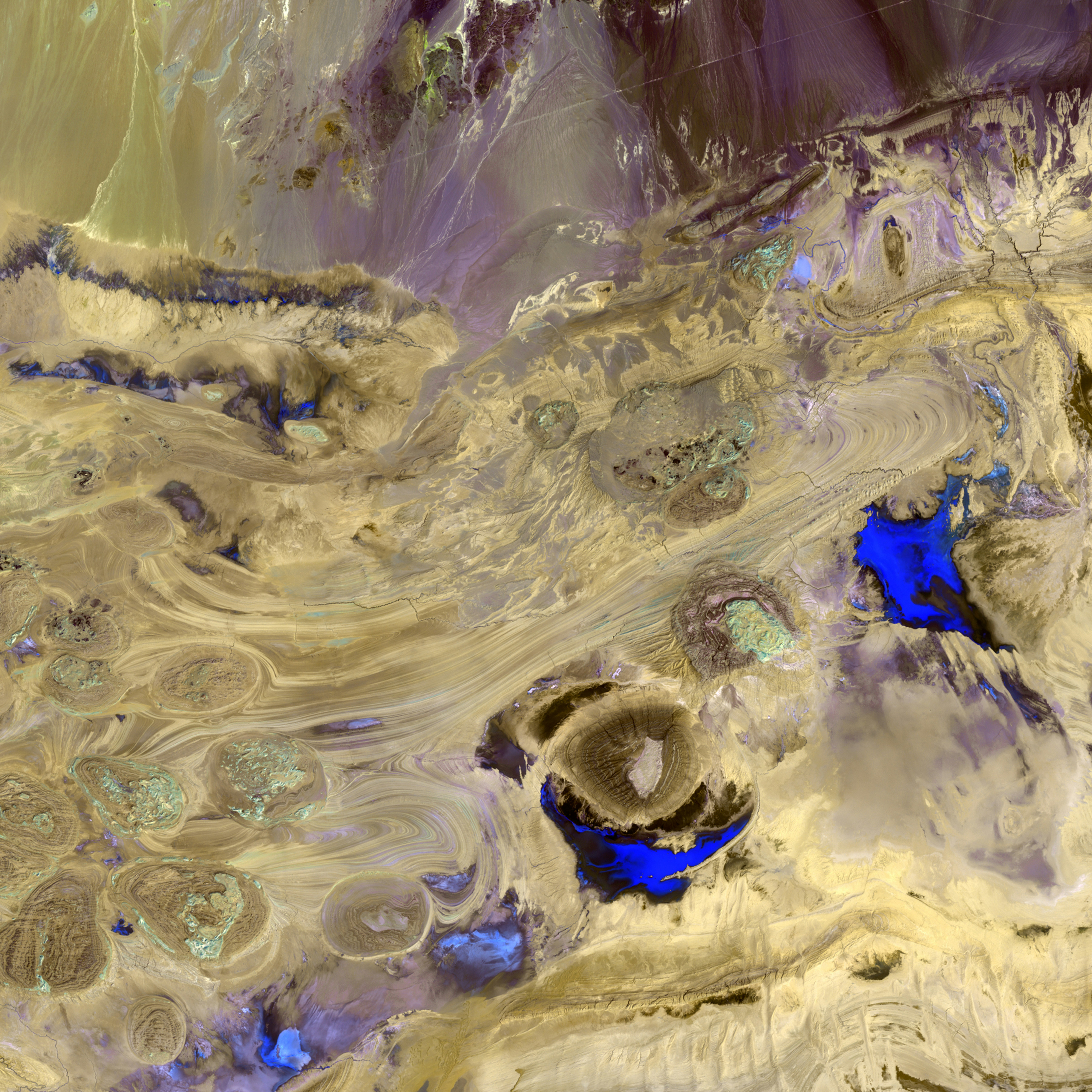 Like swirls of paint on an enormous canvas, shallow lakes, mudflats, and salt marshes share the sinuous valleys on Iran's largely uninhabited Dasht-e Kavir, or Great Salt Desert.