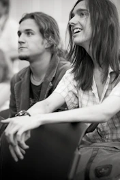 A mentor and student sharing a conversation during a community event, with smiles and engaged body language.