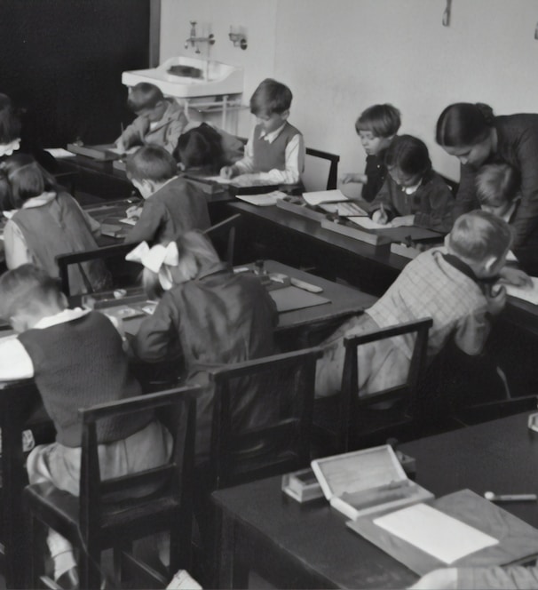 grayscale photography of children sitting inside room