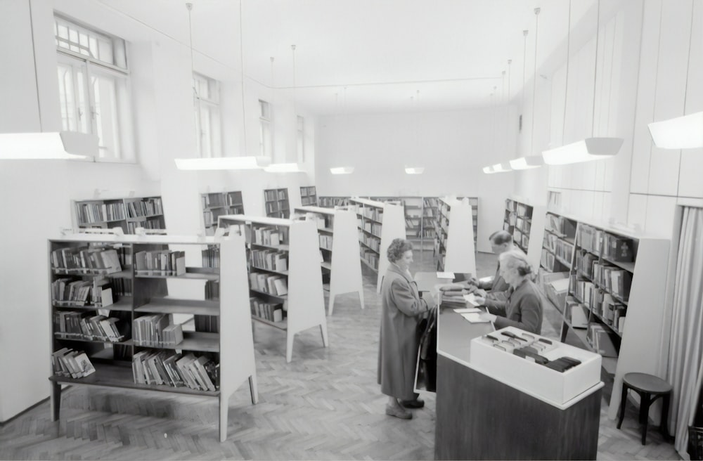 Fotografía en escala de grises de personas dentro de la librería