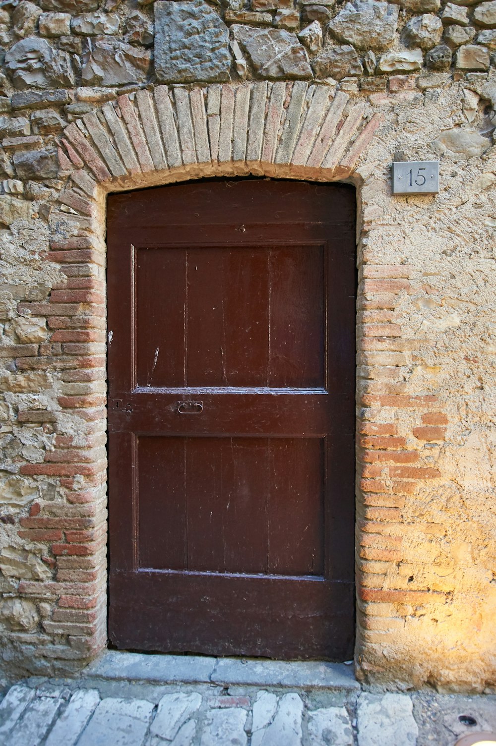 brown stone building with closed brown wooden panel door