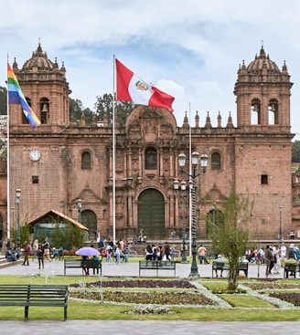 people walking near Cusco Cathedral in Peru under white and blue sky